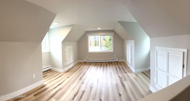 additional living space featuring light wood-type flooring, lofted ceiling, and a baseboard radiator