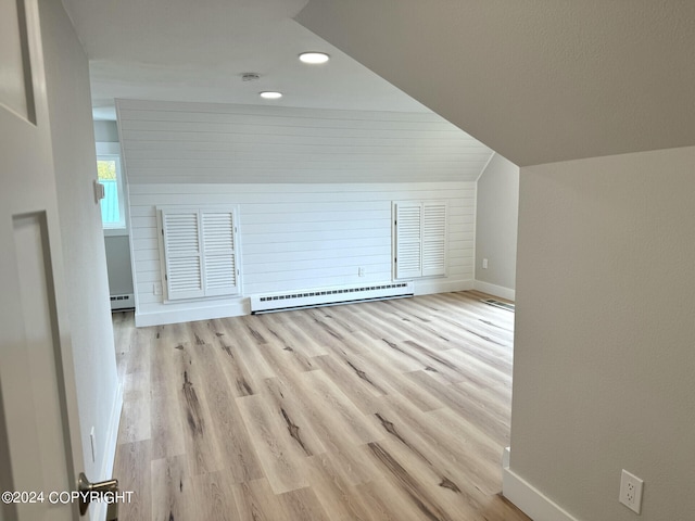 bonus room with light wood-type flooring, vaulted ceiling, and baseboard heating