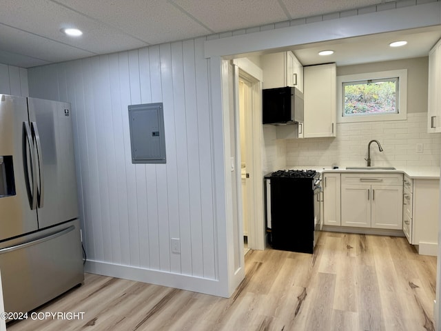 kitchen featuring backsplash, electric panel, stainless steel fridge, and white cabinetry