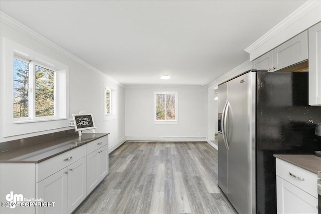 kitchen featuring white cabinetry, ornamental molding, light wood-type flooring, and stainless steel fridge with ice dispenser