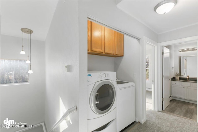 washroom featuring cabinets, independent washer and dryer, and light colored carpet