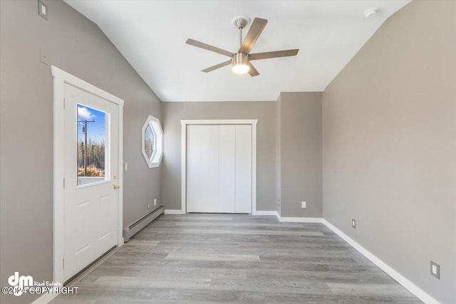 interior space with light hardwood / wood-style floors, vaulted ceiling, a baseboard radiator, and ceiling fan