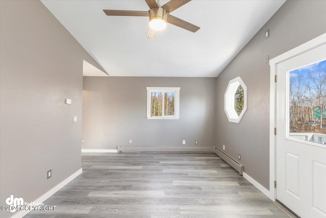 spare room with a baseboard radiator, light hardwood / wood-style floors, and ceiling fan