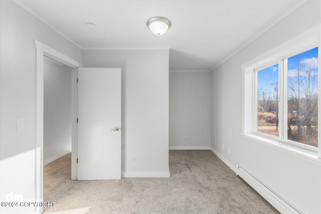 unfurnished bedroom featuring ornamental molding, a closet, a baseboard heating unit, and light colored carpet