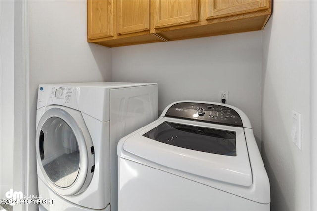 washroom with cabinets and washer and clothes dryer