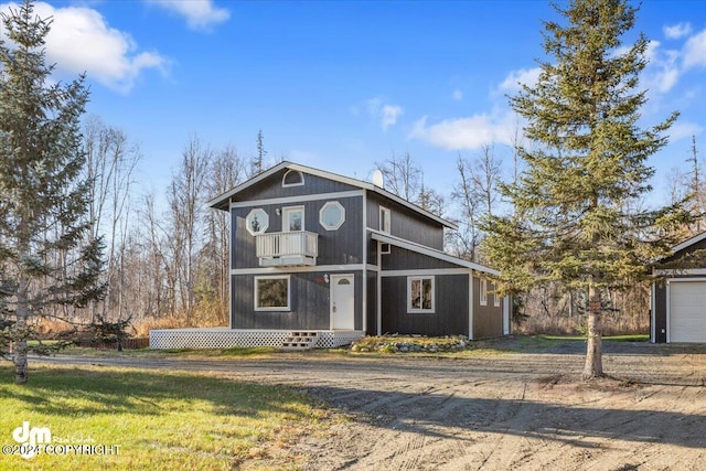 view of property with a balcony and a front lawn