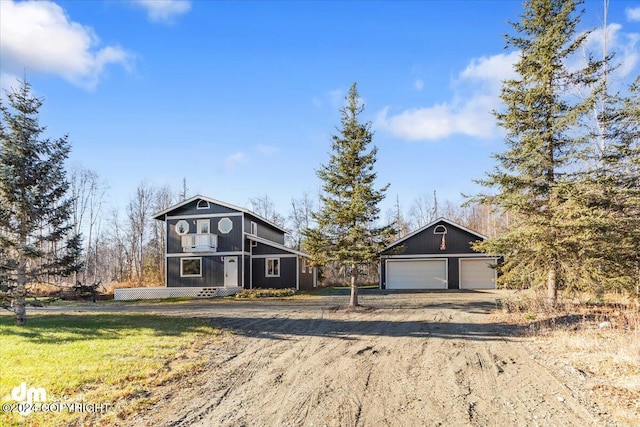 view of front of home featuring a front lawn, an outbuilding, and a garage