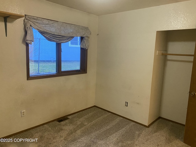 unfurnished bedroom with carpet flooring, baseboards, and visible vents