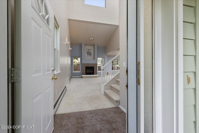 entrance foyer with vaulted ceiling, dark carpet, and baseboard heating