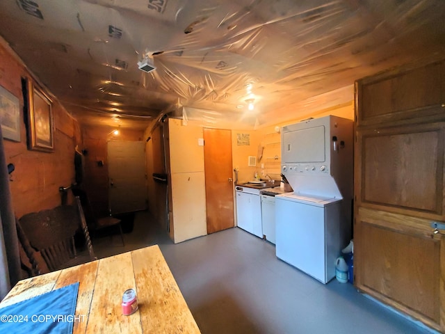 laundry room with stacked washer and clothes dryer and wood walls