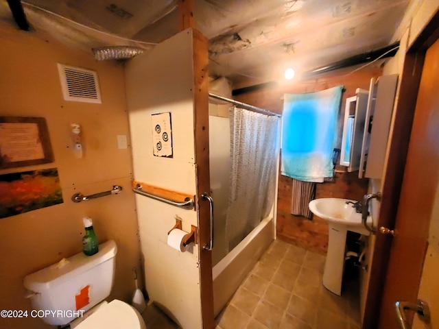 bathroom featuring toilet and shower / tub combo with curtain