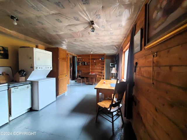 interior space featuring stacked washer / drying machine and wood walls