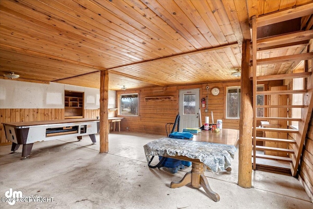 interior space with wood ceiling, wooden walls, and concrete floors