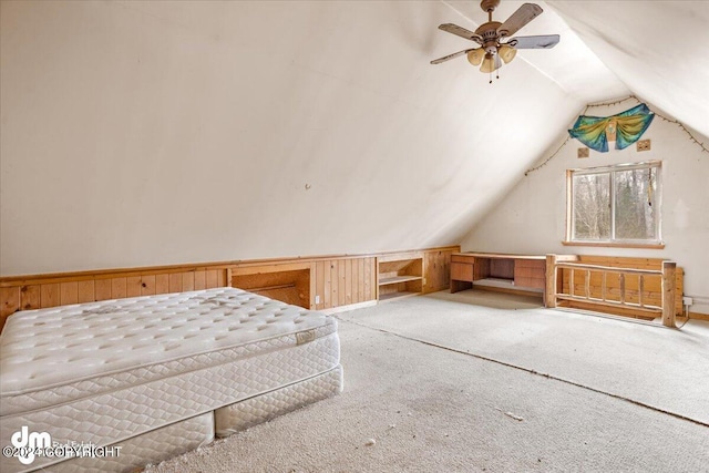 bonus room with carpet floors, vaulted ceiling, and wood walls