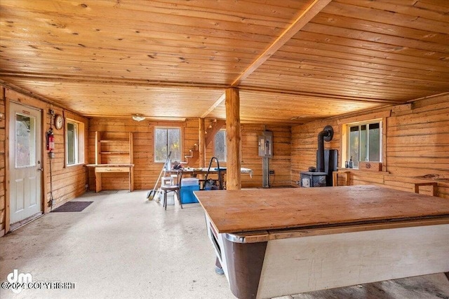 unfurnished dining area featuring electric panel, wood walls, a wood stove, and wood ceiling