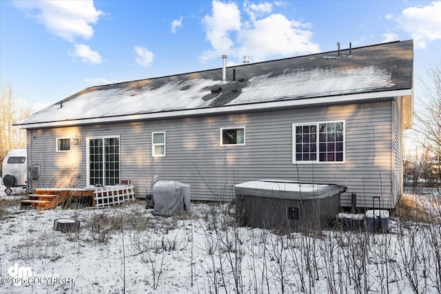 snow covered property featuring a hot tub