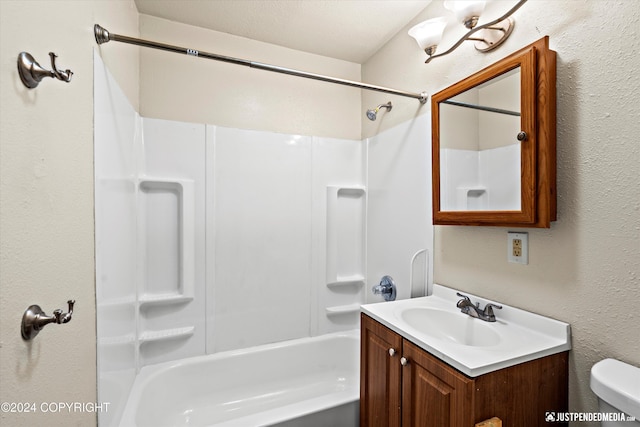 full bathroom featuring vanity, toilet, tub / shower combination, and a textured wall