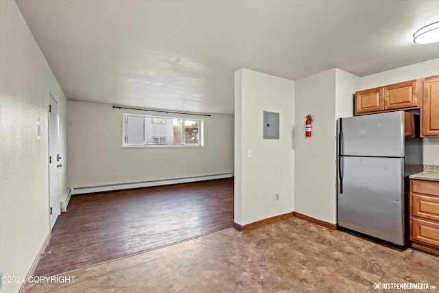 kitchen with electric panel, a baseboard heating unit, baseboards, and freestanding refrigerator