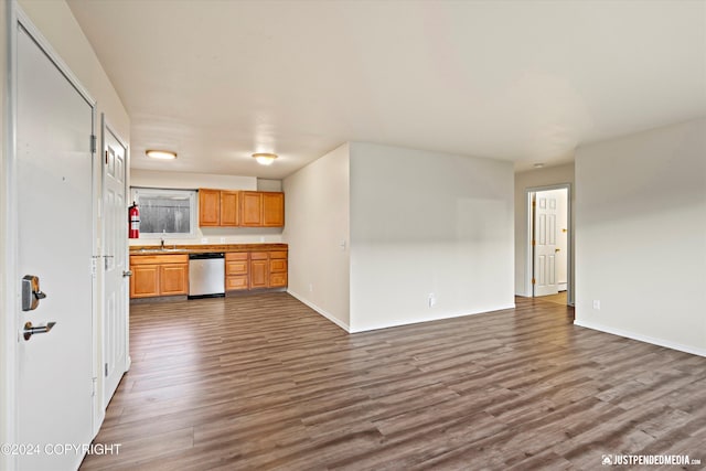 kitchen with dark wood-style floors, a sink, baseboards, and stainless steel dishwasher