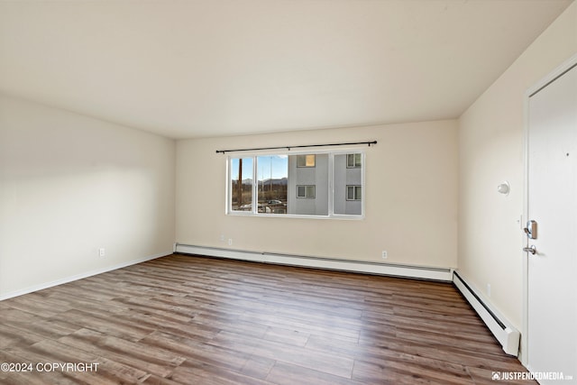 unfurnished room featuring a baseboard radiator, a baseboard heating unit, and wood finished floors