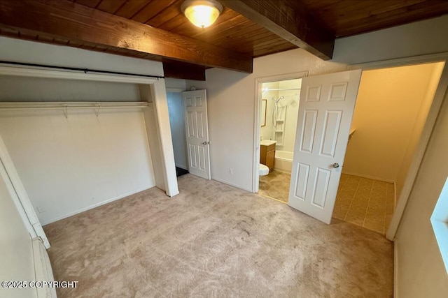 unfurnished bedroom with ensuite bath, beamed ceiling, wood ceiling, and carpet