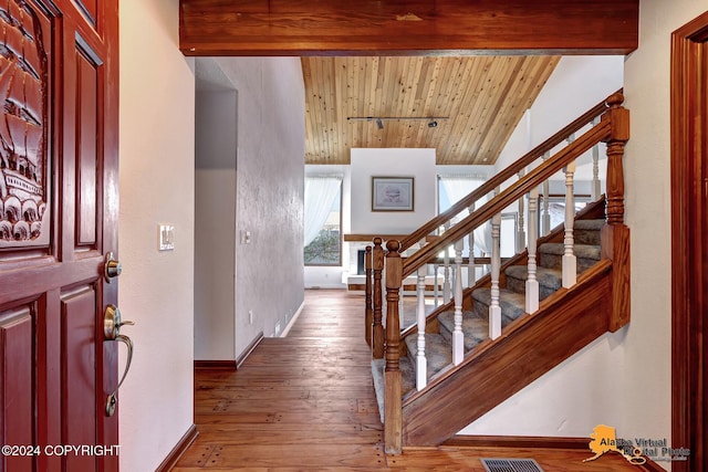 entryway with vaulted ceiling with beams, wood ceiling, and hardwood / wood-style floors