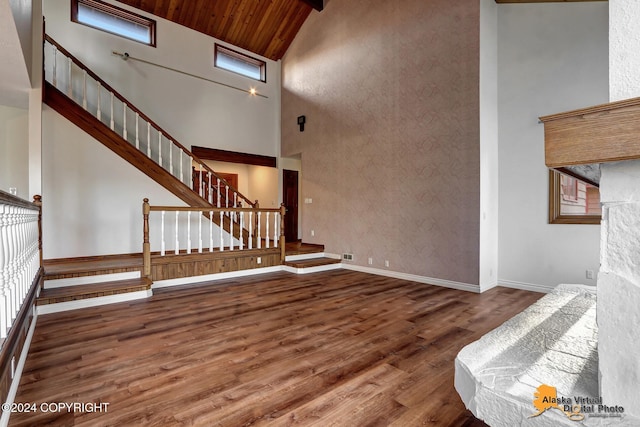 unfurnished living room with wooden ceiling, high vaulted ceiling, and wood-type flooring