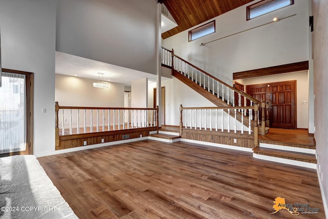 interior space with an inviting chandelier, hardwood / wood-style flooring, high vaulted ceiling, and wooden ceiling