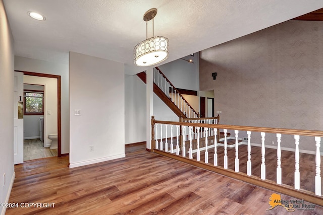 interior space with a textured ceiling and wood-type flooring