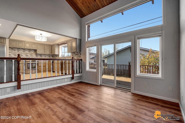 interior space with high vaulted ceiling, hardwood / wood-style flooring, wooden ceiling, and plenty of natural light