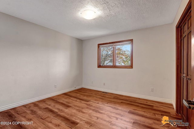 unfurnished bedroom with light hardwood / wood-style floors and a textured ceiling