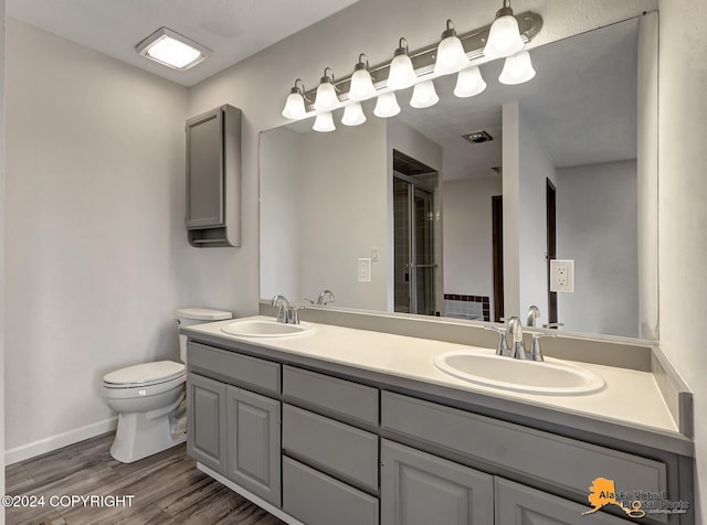 bathroom with vanity, wood-type flooring, toilet, and walk in shower