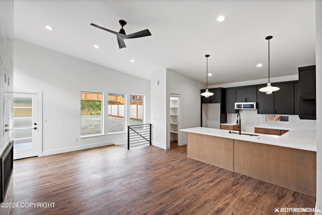 kitchen with lofted ceiling, ceiling fan, dark wood-type flooring, sink, and hanging light fixtures