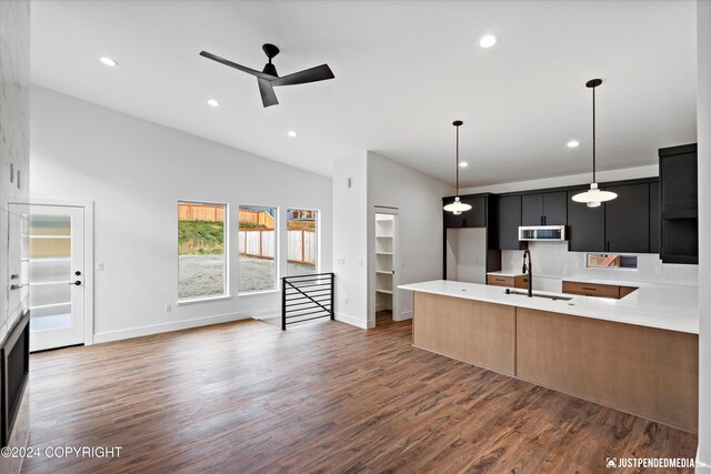 5376 Sandhill Loop, Anchorage, AK 99502 - kitchen featuring wood finished floors, a sink, ceiling fan, stainless steel microwave, and dark cabinets