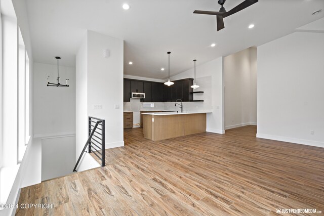5376 Sandhill Loop, Anchorage, AK 99502 - kitchen with light wood finished floors, stainless steel microwave, open floor plan, a ceiling fan, and light countertops