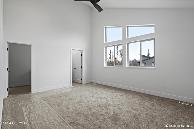 5376 Sandhill Loop, Anchorage, AK 99502 - unfurnished room featuring ceiling fan, baseboards, a high ceiling, carpet flooring, and visible vents