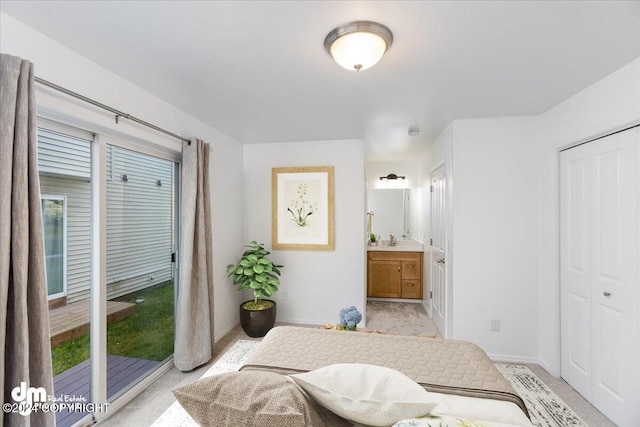 carpeted bedroom featuring a closet, ensuite bath, access to outside, and sink