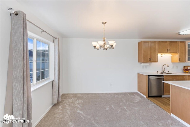 kitchen featuring dishwasher, sink, a notable chandelier, pendant lighting, and light colored carpet