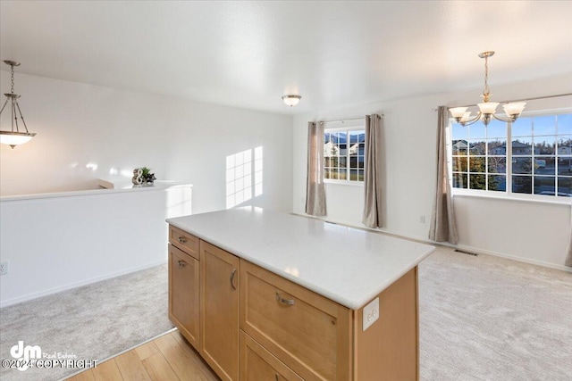 kitchen featuring an inviting chandelier, a center island, decorative light fixtures, and light wood-type flooring