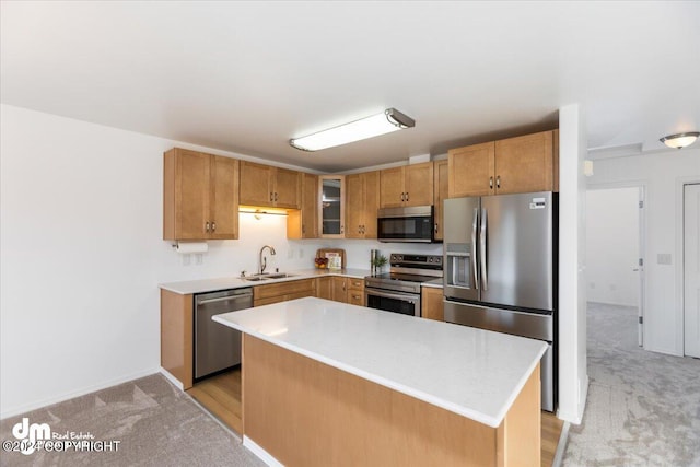 kitchen featuring appliances with stainless steel finishes, a center island, light carpet, and sink