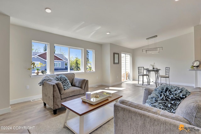 living room with light wood-type flooring and vaulted ceiling