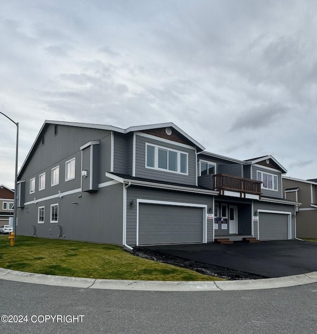 view of front of property featuring a front lawn, a balcony, and a garage