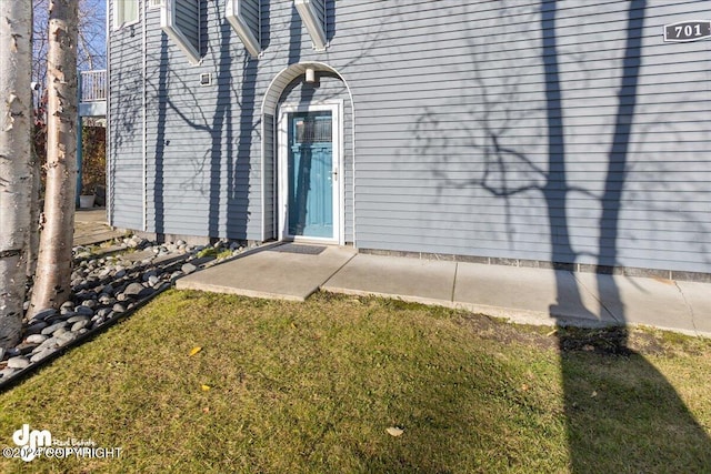 doorway to property with a lawn