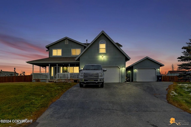 view of front facade featuring a garage, a yard, and covered porch