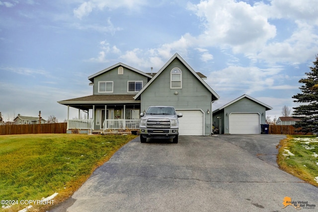 view of front of property with a garage, a porch, and a front lawn