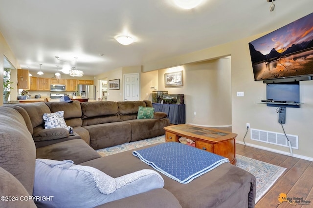 living room featuring dark hardwood / wood-style flooring and an inviting chandelier