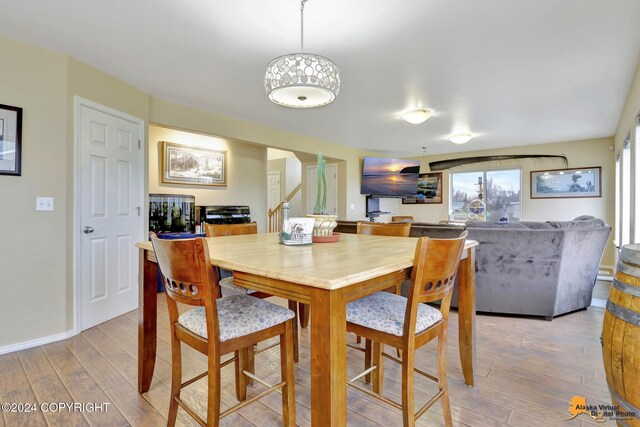 dining space featuring ornate columns and light hardwood / wood-style floors