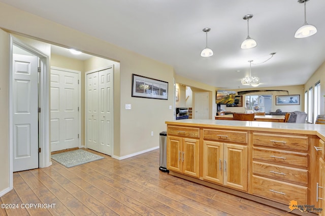 kitchen with a chandelier, decorative light fixtures, and light hardwood / wood-style flooring