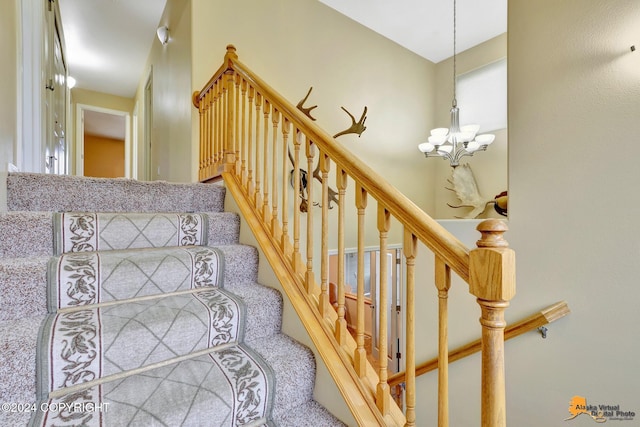 stairway with a notable chandelier and carpet flooring