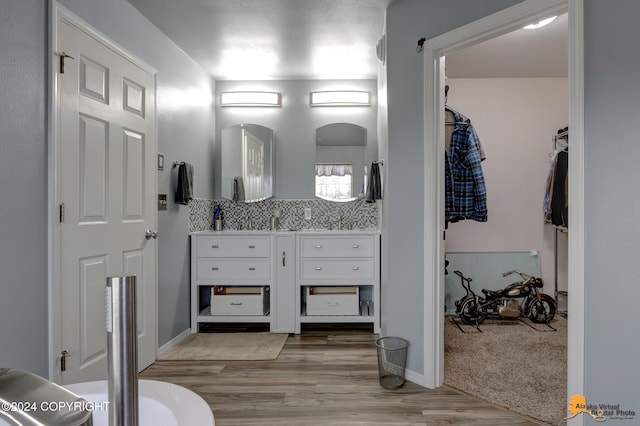 bathroom featuring decorative backsplash, wood-type flooring, and vanity